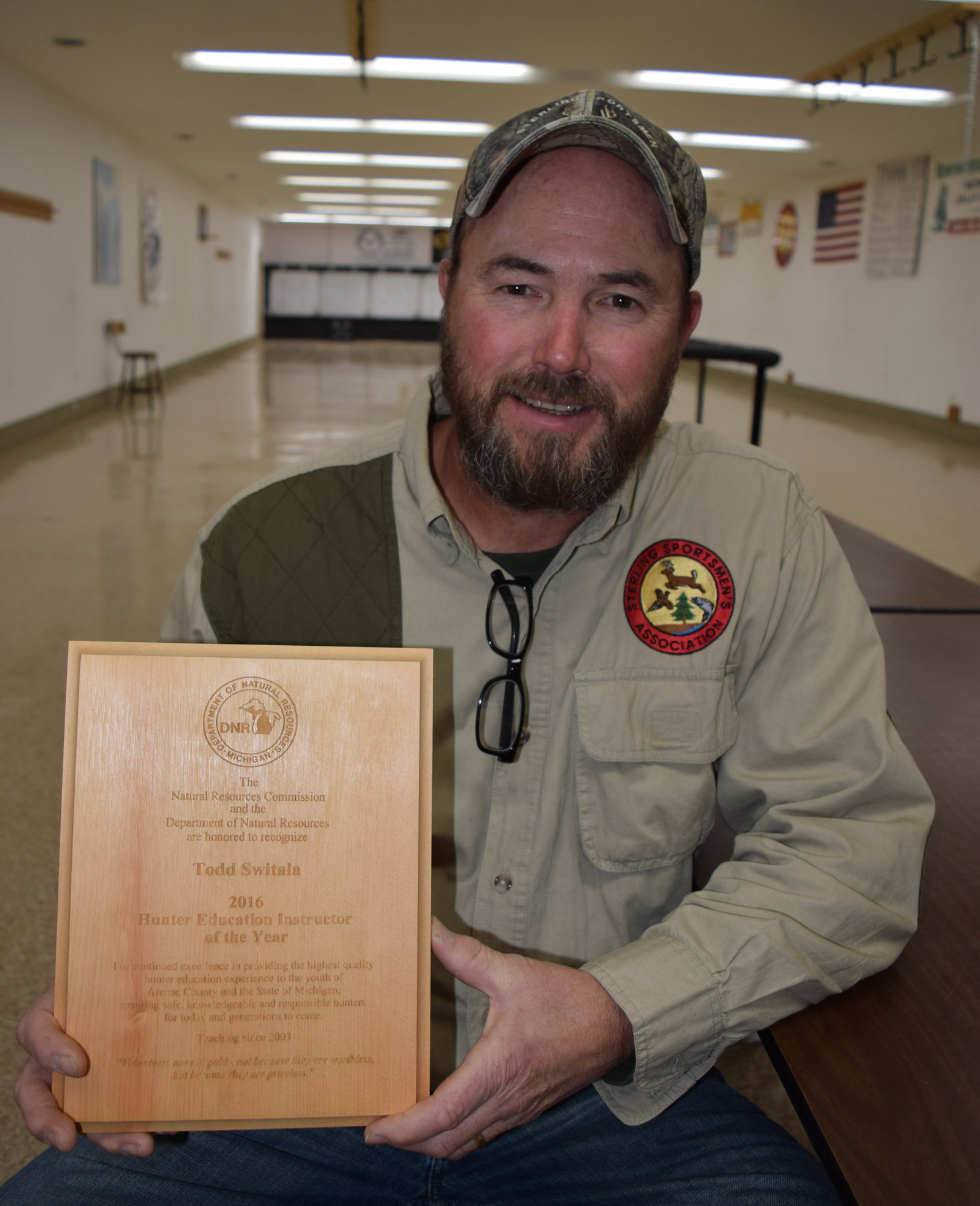 Todd Switala, 2016 Hunter Safety Instructor of the Year displays a plaque recognizing his service.