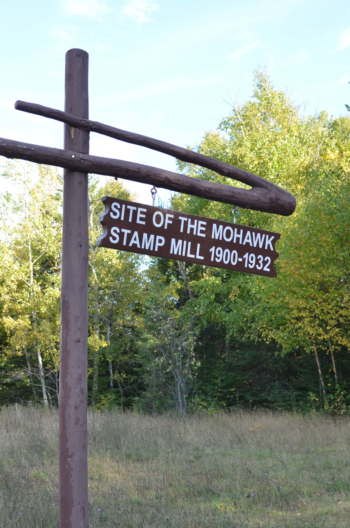 A sign posted next to the smokestack and ruins of the stamp sands mill at Gay.