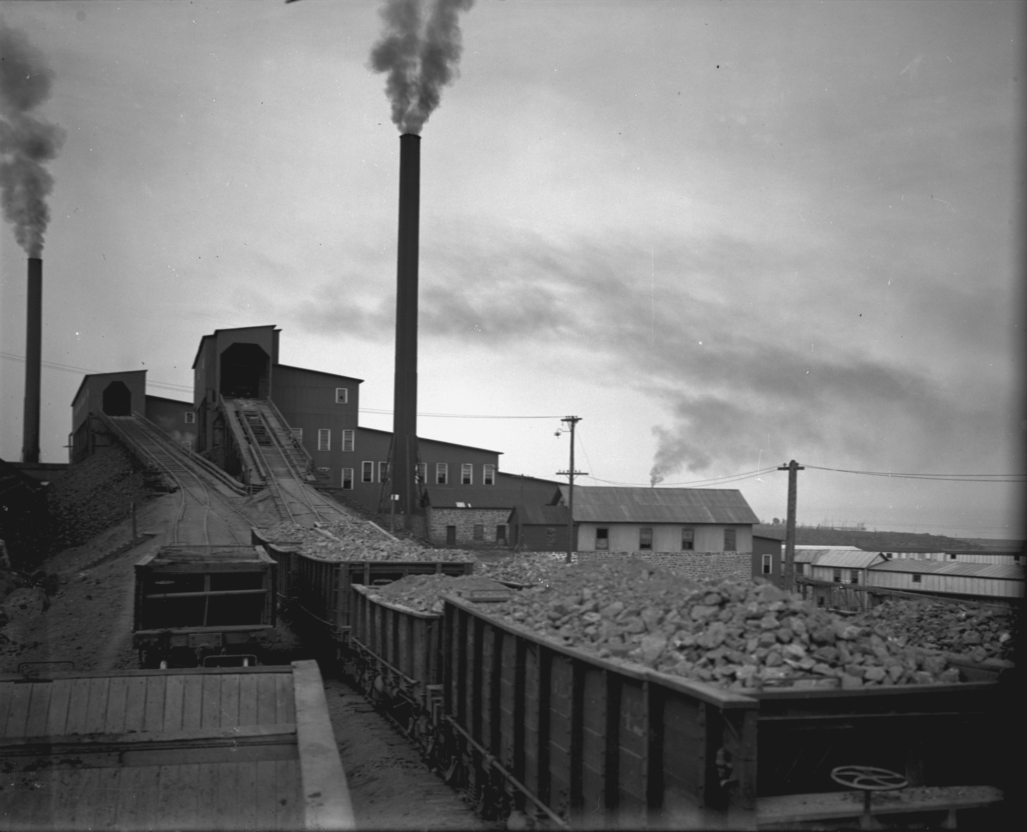 A line of carts carrying copper-rich rock wait to move into a stamp mill for the Mohawk and Wolverine mines. (Photo courtesy Michigan Tech Archives)  