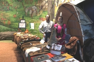 a display of Native culture artifacts with man and girl standing by table