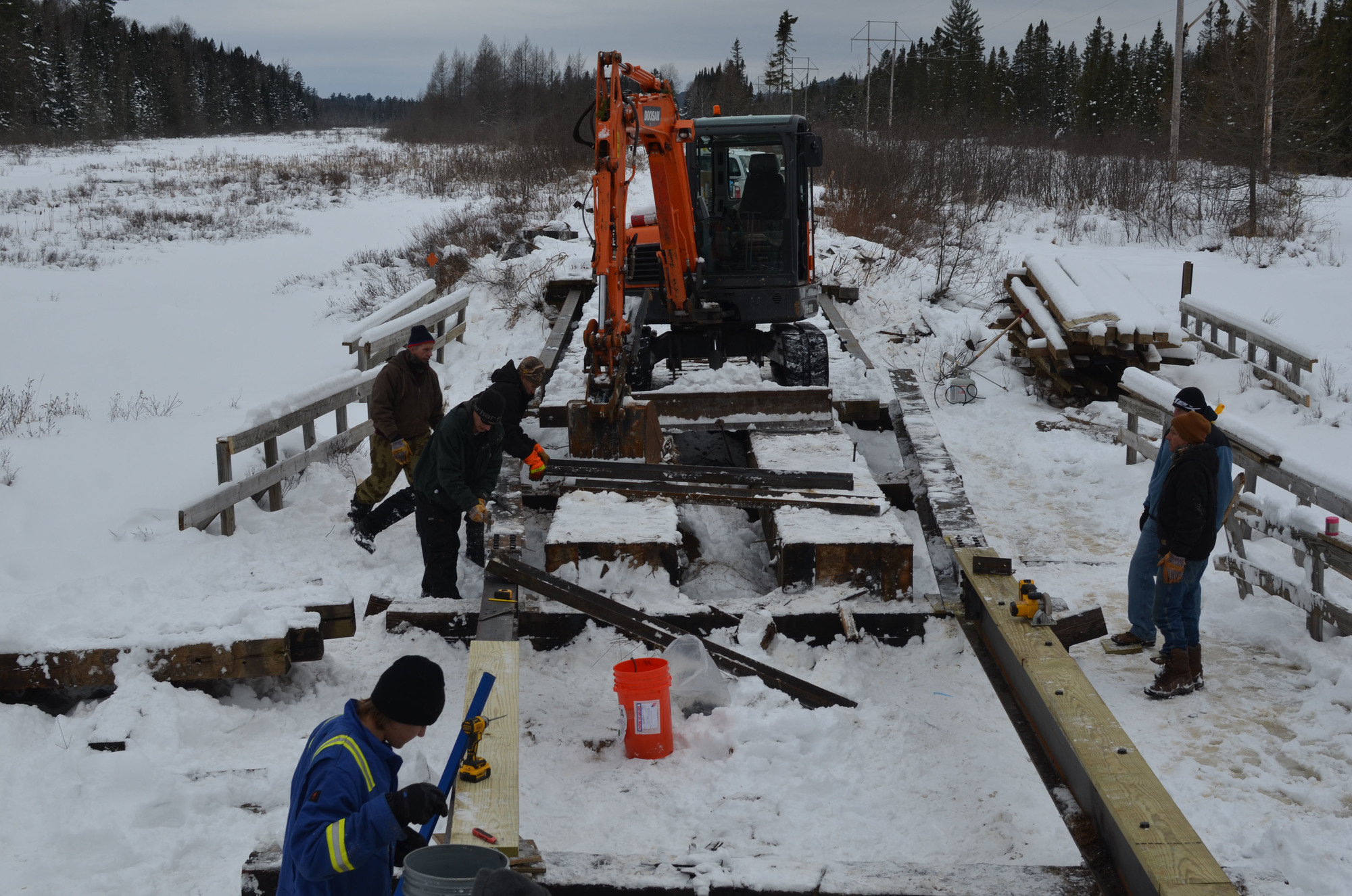 Workers replace a cracked Clowry Grade bridge support beam along Snowmobile Trail No. 8 in Marquette County.
