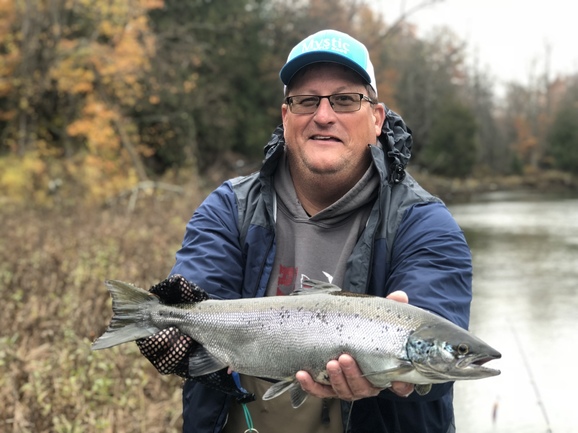 Angler holding Atlantic salmon caught on Au Sable River