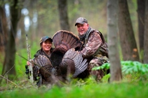 male and female hunters with harvested turkey
