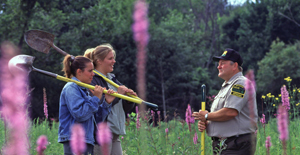 Two volunteers on a habitat project talk with a state park ranger.
