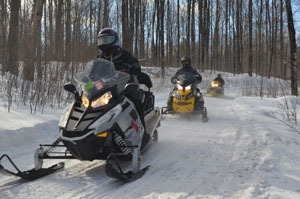 Snowmobilers move along Trail No. 11 South on a sunny day in Gogebic County.