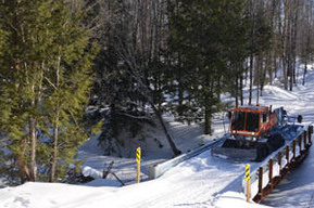 A groomer rides across the new Mud Creek Bridge in Gogebic County.