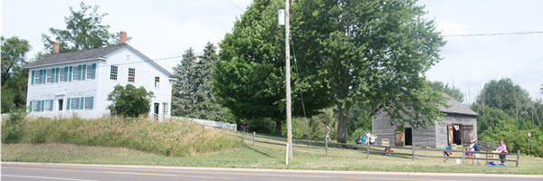 Walker Tavern, on the left, and the reconstructed barn, at right, as viewed from US-12