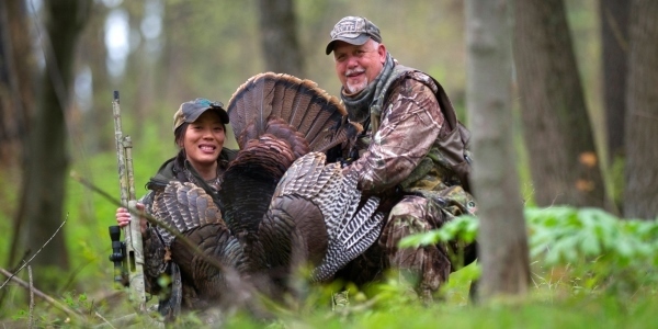 female and male hunters with turkey