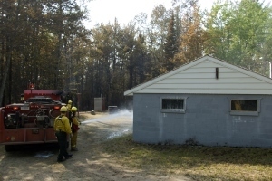 DNR fire officers work to protect a structure during a wildfire