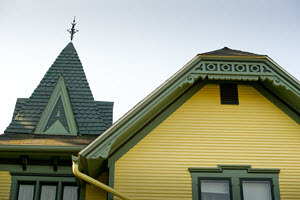 The front roofline of the Mann House includes detailed wood trim and a tower.