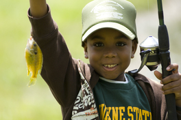 Little boy holding up a panfish he caught