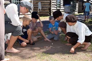 Park visitors play games with Future Historians at Fort Wilkins.