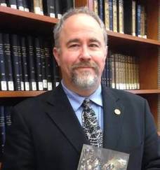 Head shot of David Lambert in front of a bookshelf
