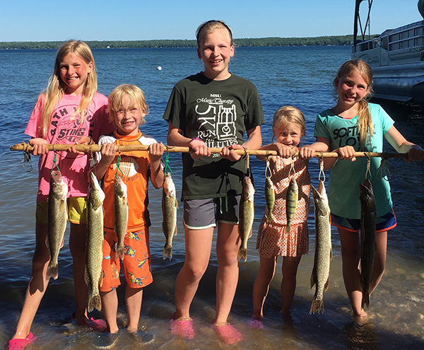 Kids holding up their catch while standing in water