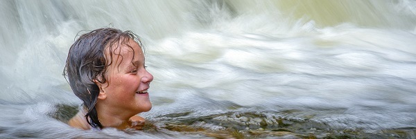 Girl swimming in Ocqueoc Falls, the only publicly accessible waterfall in Michigan's Lower Peninsula 