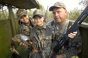 Man and two boys waterfowl hunting in duck blind