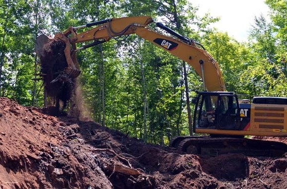 A contractor dumps sand and rocks removed from a storm sewer in Houghton County.