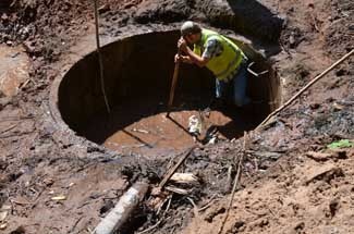 A worker tries to unplug a storm sewer in Houghton County.