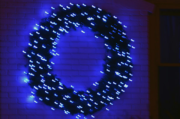 A holiday wreath adorned in blue lights on a home in Marquette County.