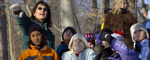 park interpreter leading kids on a winter hike at a state park