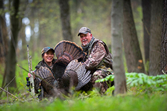 Man and woman hunters with turkey