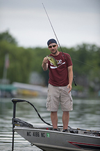 fisherman on fishing boat holding bass