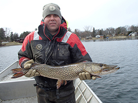 Cleyo Harris holding a northern pike caught during Lake Orion survey