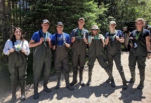 a group of teenage boys and girls dressed in fishing waders