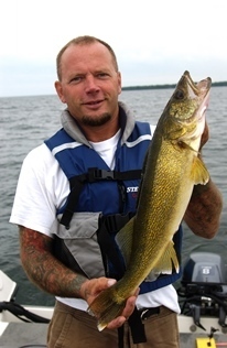 fisherman on boat holding walleye