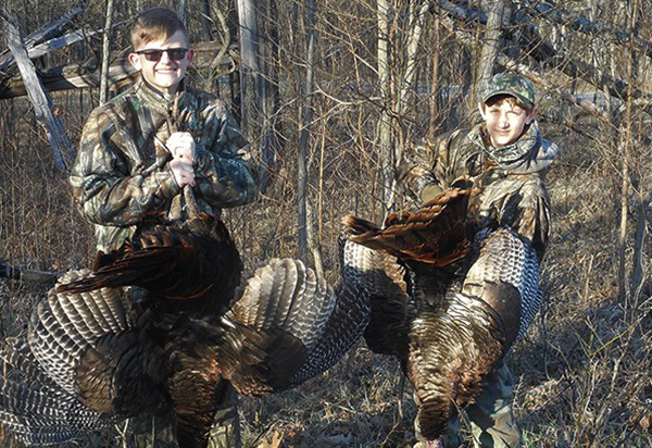 two young male hunters with turkeys