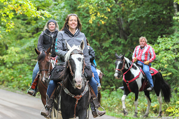 A group of horseback riders enjoys a ride at Mackinac Island State Park.