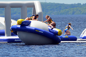 two girls enjoy an inflatable water park structure