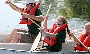 smiling girl in canoe holding paddle