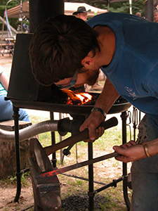 blacksmith pounding hot metal with hammer