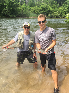 Two anglers holding rainbow trout they caught at Hodenpyl Reach on Manistee River