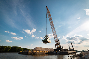 Heavy machinery moving stone for reef restoration work