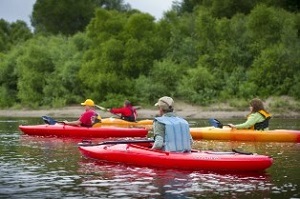 Kayakers wearing life jackets paddling down the Muskegon River