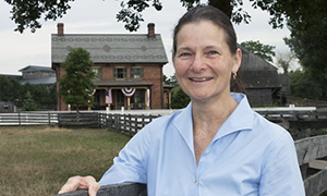 Dr. Debra Reid with farmhouse in background