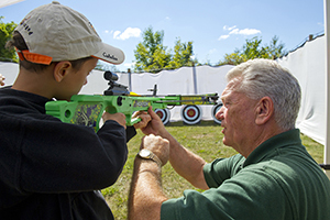 DNR staffer teaches boy to shoot crossbow