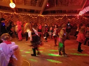 Children dressed in Halloween costumes are hula-hooping. 