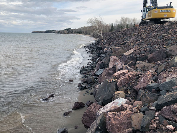 A excavator is shown along a fortified shoreline at Lake Superior.