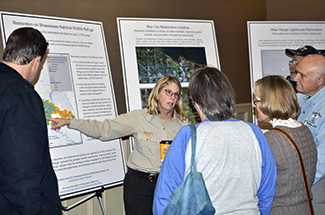 A U.S. Fish and Wildlife Service worker talks with people about recovery projects.