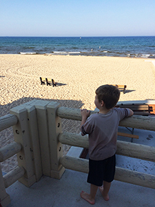 boys looks out at Lake Michigan from Ludington State Park beach house