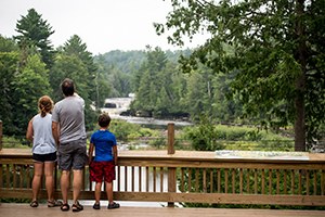 Man and two children look out at Lower Tahquamenon Falls