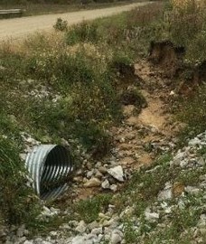 Sand and rocks erode into a culvert
