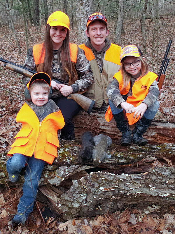 Two children and their parents are pictured after a successful squirrel hunt.