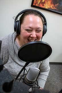 Holly Vaughan laughs during a podcast recording.