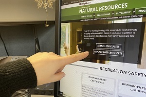 Someone's finger pointing to the "replace lost certificate" button on the DNR recreational safety webpage