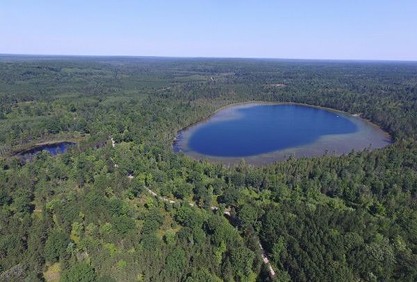 An aerial view of Walled Lake and surrounded forested areas in the Pigeon River Country State Forest