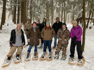 Group of people in snowshoes in snowy forest